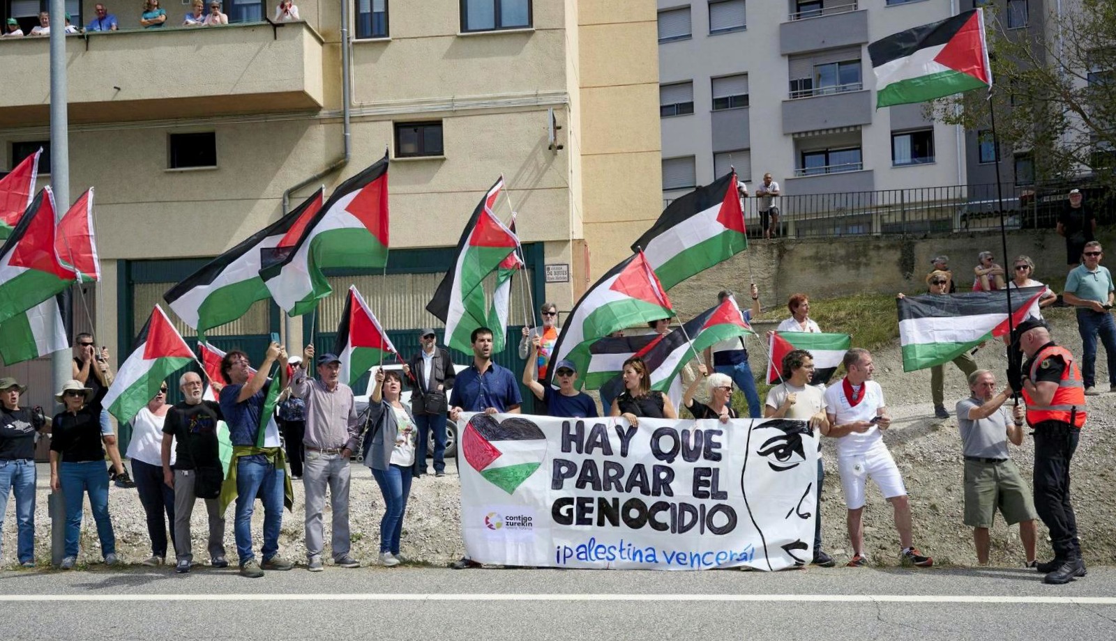 Militantes de la coalición Contigo Navarra - Zurekin Nafarroa, protestando por el genocidio palestino en Lumbier, al paso del pelotón.