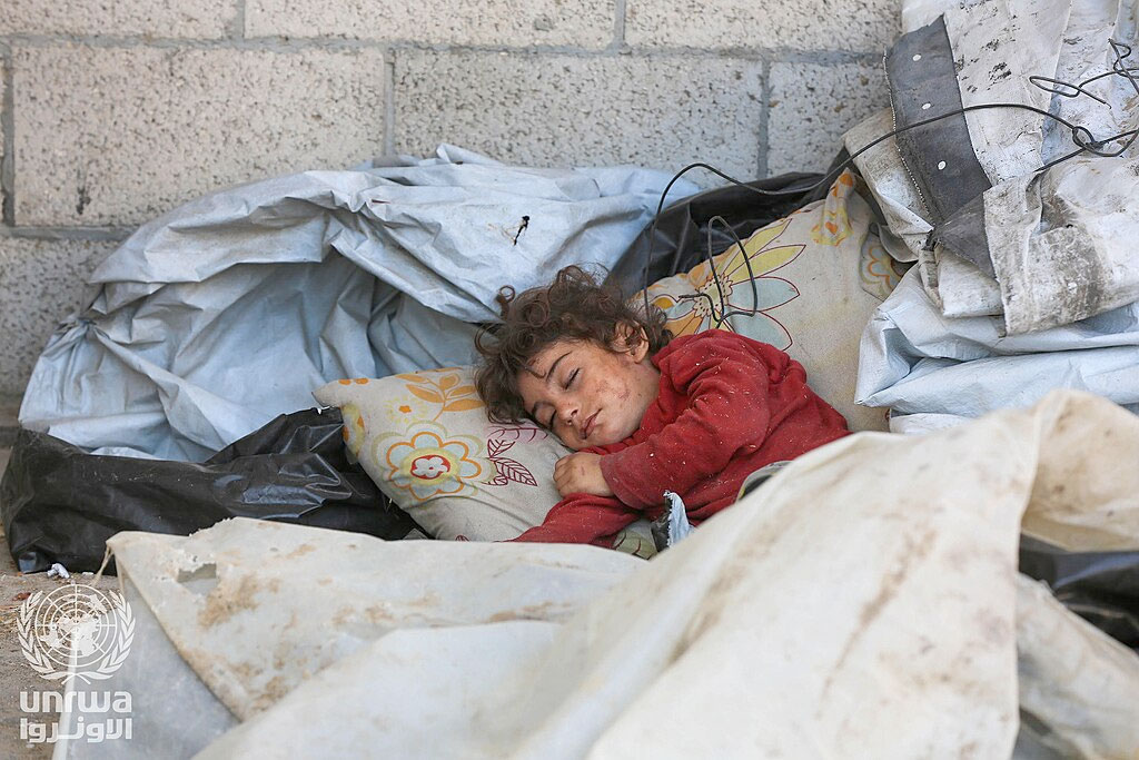 Niña palestina durmiendo en la calle después de ser expulsada de su vivienda en Deir al-Balah (2024) | Fuente: Wikimedia commons / Ashraf Amra - United Nations Relief and Works Agency for Palestine Refugees in the Near East / CC BY-SA 3.0 IGO