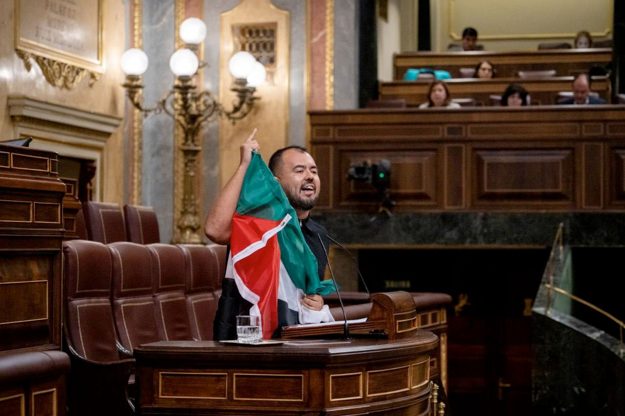 El diputado Nahuel González con una bandera palestina en la tribuna del Congreso de los Diputados durante una intervención en el Pleno | Foto: Olmo Calvo
