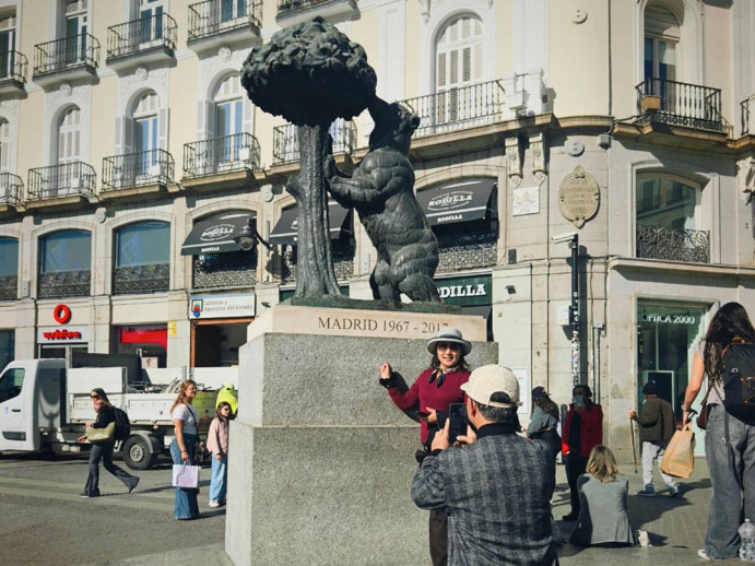 Turistas chinos se toman fotos junto a la icónica escultura "El Oso y el Madroño" en Madrid, España | Fuente: Xu Hailin/Diario del Pueblo